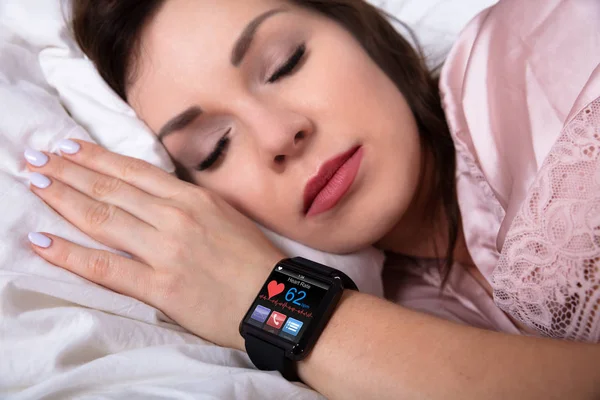 Wanita Cantik Tidur Ranjang Dengan Jam Pintar Menunjukkan Detak Jantung — Stok Foto