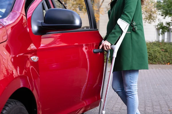 Disabled Young Woman Crutches Opening Door Red Car — Stock Photo, Image