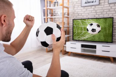 Heyecanlı Adam TV 'de futbol maçının keyfini çıkarıyor.