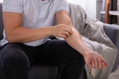 Kaşıntı gelen acı kanepede oturan bir adam görünümünü midsection