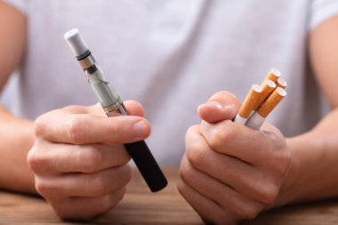 Vape ve tütün sigara Resepsiyon üzerinde tutan adam