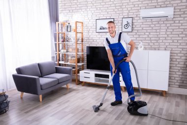 Erkek hademe yere elektrikli süpürge ile temizlik yüksek açılı görünüş
