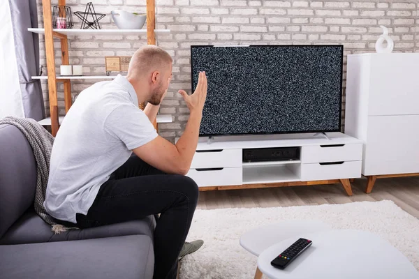 Hombre Joven Frustrado Sentado Sofá Cerca Televisión Sin Señal — Foto de Stock