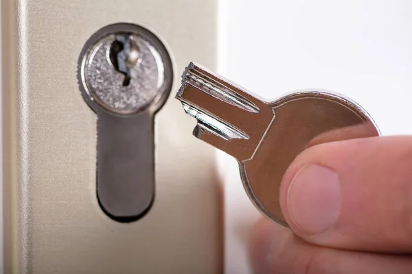 鍵穴の近くで壊れた鍵を持っている男のクローズアップ — ストック写真