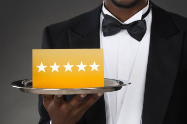 Bir garsonun el ile beş yıldızlı Rating plaka tutarak Close-Up