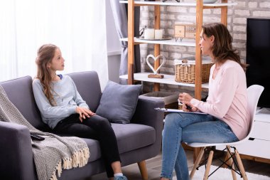 Evde kadın psikiyatrist onun sorunları açıklayan kanepede oturan kız