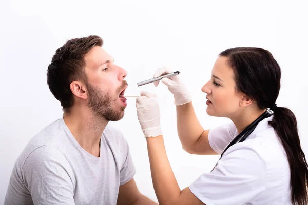 Ung Kvinnlig Doktor Kontrollerar Mannens Ömma Hals Med Tungtryckare — Stockfoto