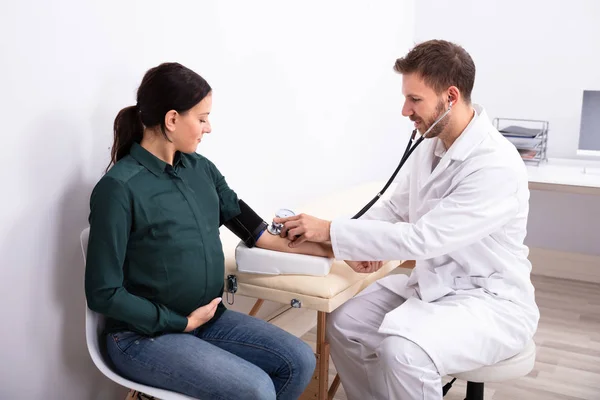 Jovem Médico Verificando Pressão Arterial Paciente Feminina Sorridente Clínica — Fotografia de Stock