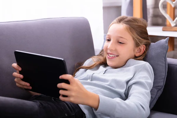 Gelukkig Meisje Liggend Bank Met Behulp Van Digitale Tablet — Stockfoto