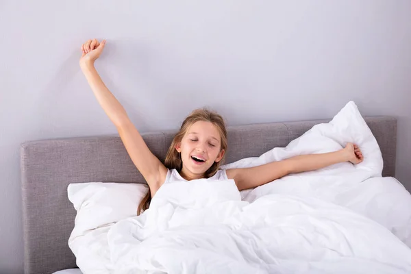 Portrait Girl Sitting Bed Stretching Her Arms Bedroom — Stok Foto