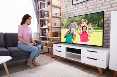 Televizyon izlerken koltukta oturan genç kadın