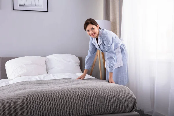 Sorrindo Empregada Feminina Fazendo Cama Quarto Hotel — Fotografia de Stock