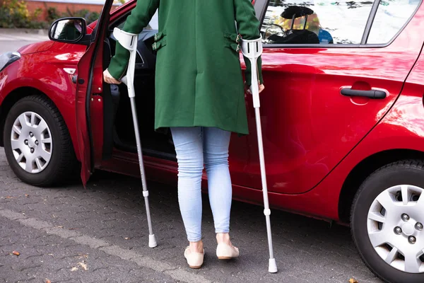 残疾人的年轻女子与拐杖打开门的红色汽车 — 图库照片