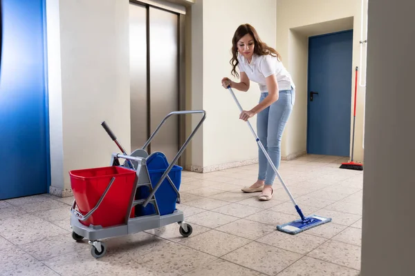 Jovem Janitor Feminino Limpeza Chão Com Esfregão Corredor — Fotografia de Stock