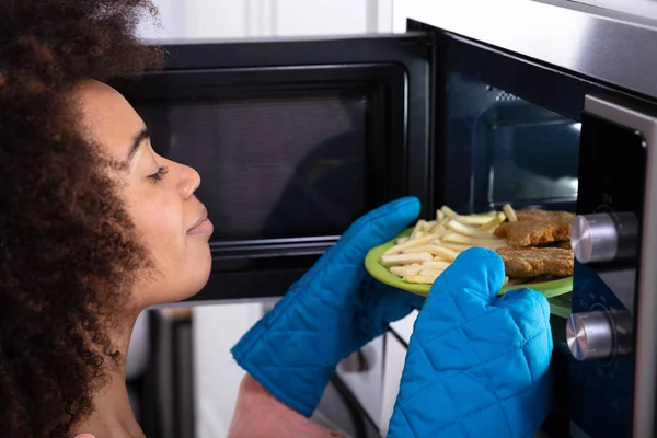 Jonge Vrouw Blauwe Mitt Dragen Handen Verwarming Gebakken Voedsel Magnetron — Stockfoto