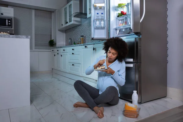 Mujer Embarazada Joven Comiendo Pedazo Pastel Sentado Frente Refrigerador Abierto — Foto de Stock