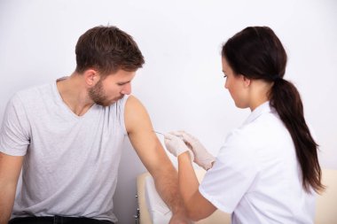 Genç Kadın Doktor Klinikteki Erkek Hastaya Şırınga Enjekte Ediyor
