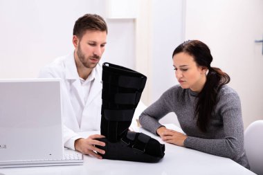 Doktor ve Kadın Hasta Klinikte Yürüyen İplerle Masada Oturuyor