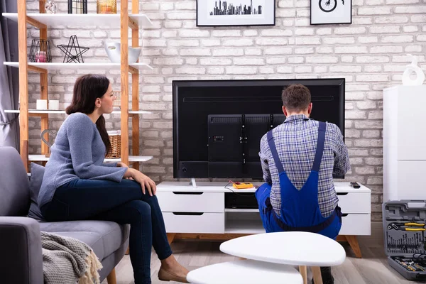 Femme Assise Sur Canapé Près Technicien Masculin Réparant Télévision — Photo