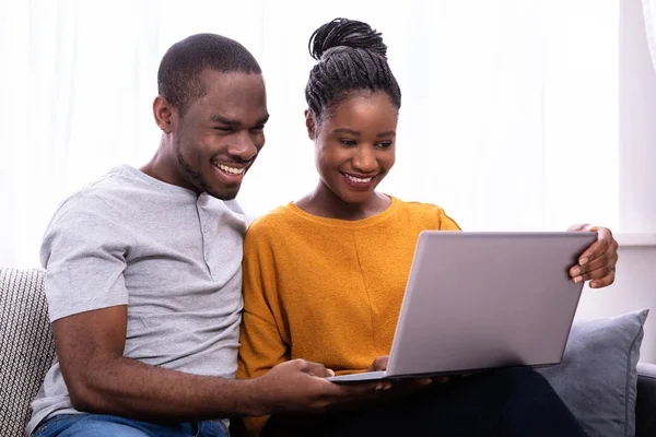 Feliz Jovem Casal Sentado Sofá Usando Laptop — Fotografia de Stock