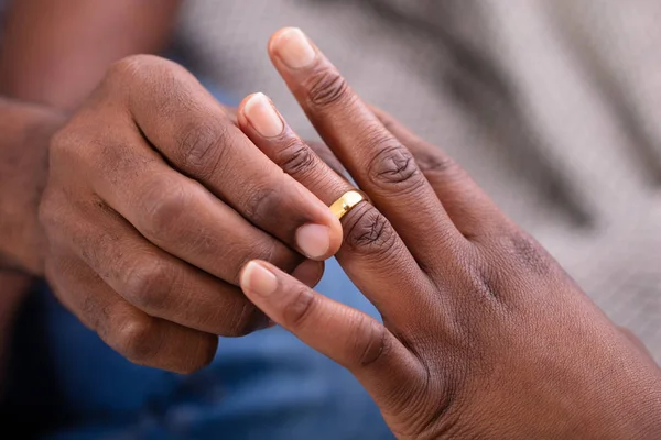 男子之手在女人的手指上戴上金订婚戒指的特写镜头 — 图库照片