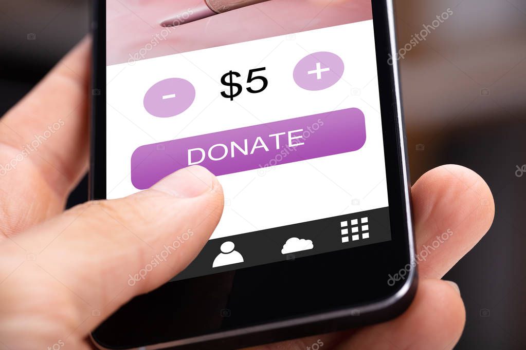 Close-up Of A Person's Hand Donating Money On Cellphone