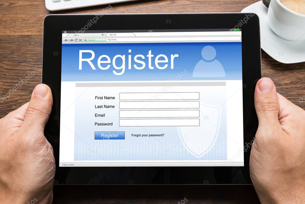 Person Holding Digital Tablet Showing Online Registration Form On Screen