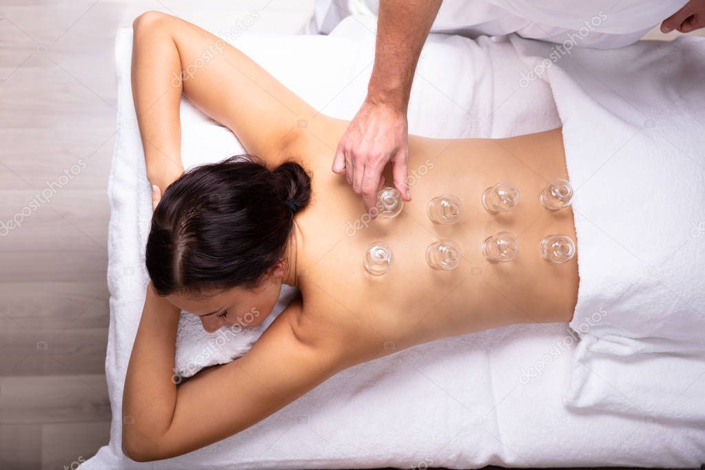 Relaxed Young Woman Receiving Cupping Treatment On Her Back In Spa