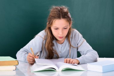 Bir kız okuma kitabı yeşil kurulu önünde portresi