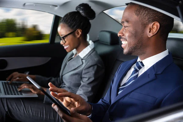 Dois Empresários Africanos Felizes Usando Dispositivos Eletrônicos Enquanto Viajam Carro — Fotografia de Stock