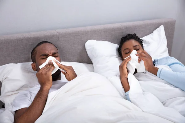 Sick African Young Couple Lying Bed Blowing Nose Bedroom — Stock Photo, Image