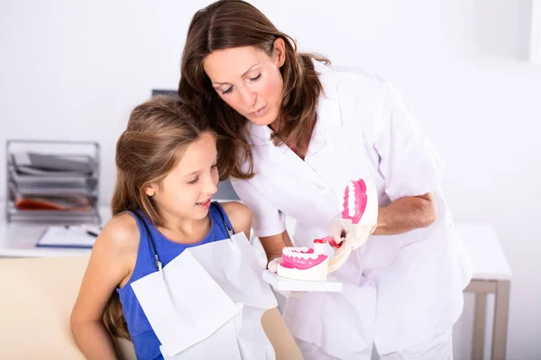 Meisje Kijkend Naar Vrouwelijke Tandarts Reiniging Van Tanden Model Met — Stockfoto