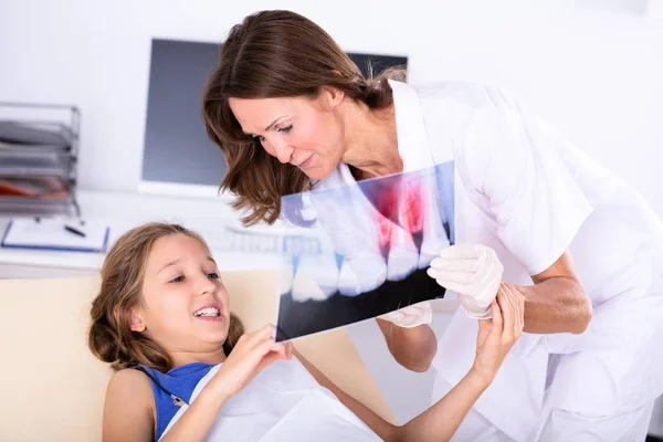 Oudere Vrouwelijke Tandarts Weergeven Tanden Ray Meisje Kliniek — Stockfoto