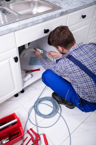 Joven Hombre Fontanero Limpieza Tapado Fregadero Tubería Cocina —  Fotos de Stock