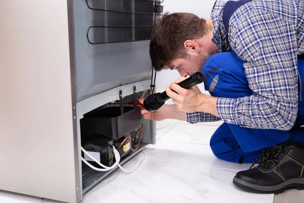 Close Handyman Verificando Refrigerador Com Lanterna Elétrica Casa — Fotografia de Stock