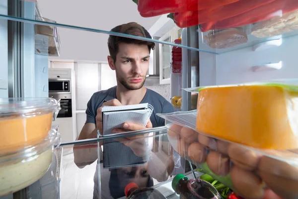 Primer Plano Del Hombre Escribiendo Espiral Libro Cerca Refrigerador Abierto —  Fotos de Stock