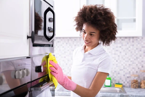 Close Smiling Female Janitor Cleaning Oven Yellow Napkin Kitchen — Stock Photo, Image