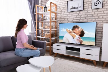 Televizyon izlerken koltukta oturan genç kadın