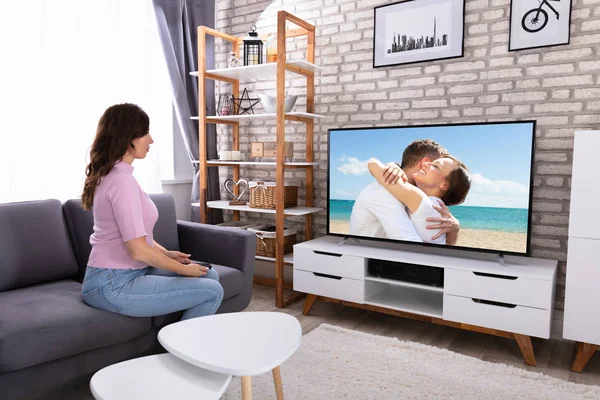 Jovem Mulher Sentada Sofá Assistindo Televisão — Fotografia de Stock