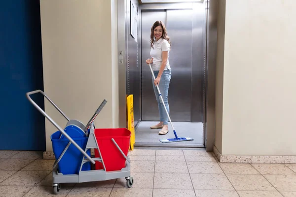 Glückliche Hausmeisterin Putzt Fahrstuhl Mit Wischmopp — Stockfoto