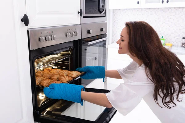 Side View Happy Young Woman Removing Tray Baked Croissants Oven — Stock Photo, Image