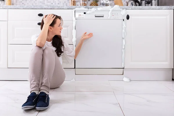 Vrouw Zit Van Beschadigde Vaatwasser Met Schuim Vanuit Het Verstoord — Stockfoto