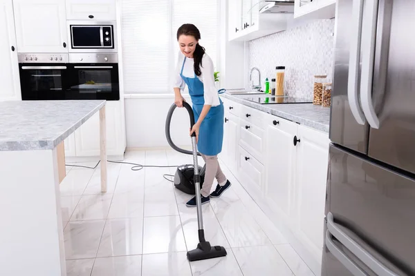 Junge Hausmeisterin Uniform Putzt Küchenboden Mit Staubsaugerboden — Stockfoto