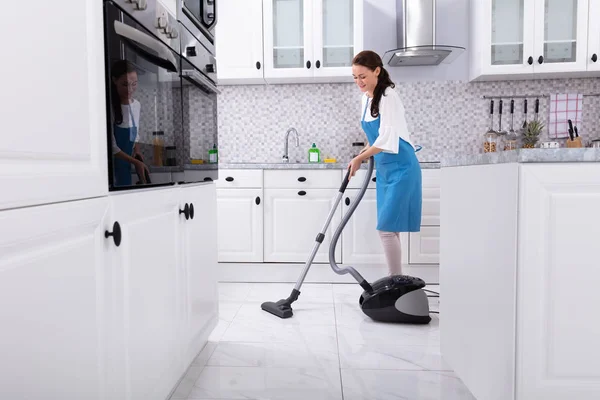 Junge Hausmeisterin Uniform Putzt Küchenboden Mit Staubsaugerboden — Stockfoto