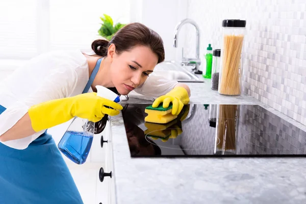 Giovane Donna Pulizia Induzione Stufa Con Spugna Cucina — Foto Stock