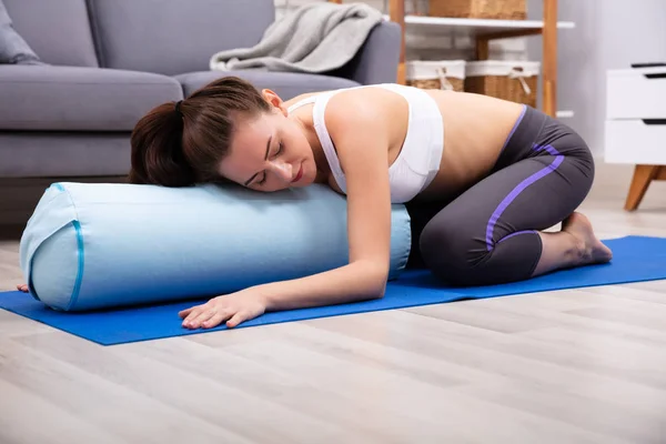 Genç Kadın Evde Yoga Bolster Üzerinde Uygulamak — Stok fotoğraf