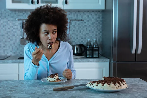 Young African Woman Eating Piece Cake Spoon Sitting Kitchen — Stock Photo, Image