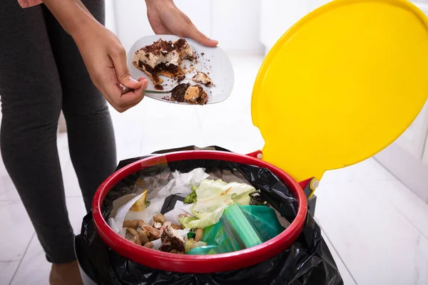 Womans Hand Throwing Cake Trash Bin — 스톡 사진