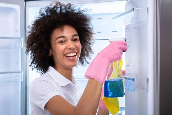 Genç Mutlu Temizlikçi Kadın Boş Buzdolabının Kapısını Püskürtülen Ilaç Şişe — Stok fotoğraf