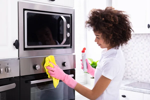 Close Smiling Female Janitor Cleaning Oven Yellow Napkin Kitchen — Stock Photo, Image